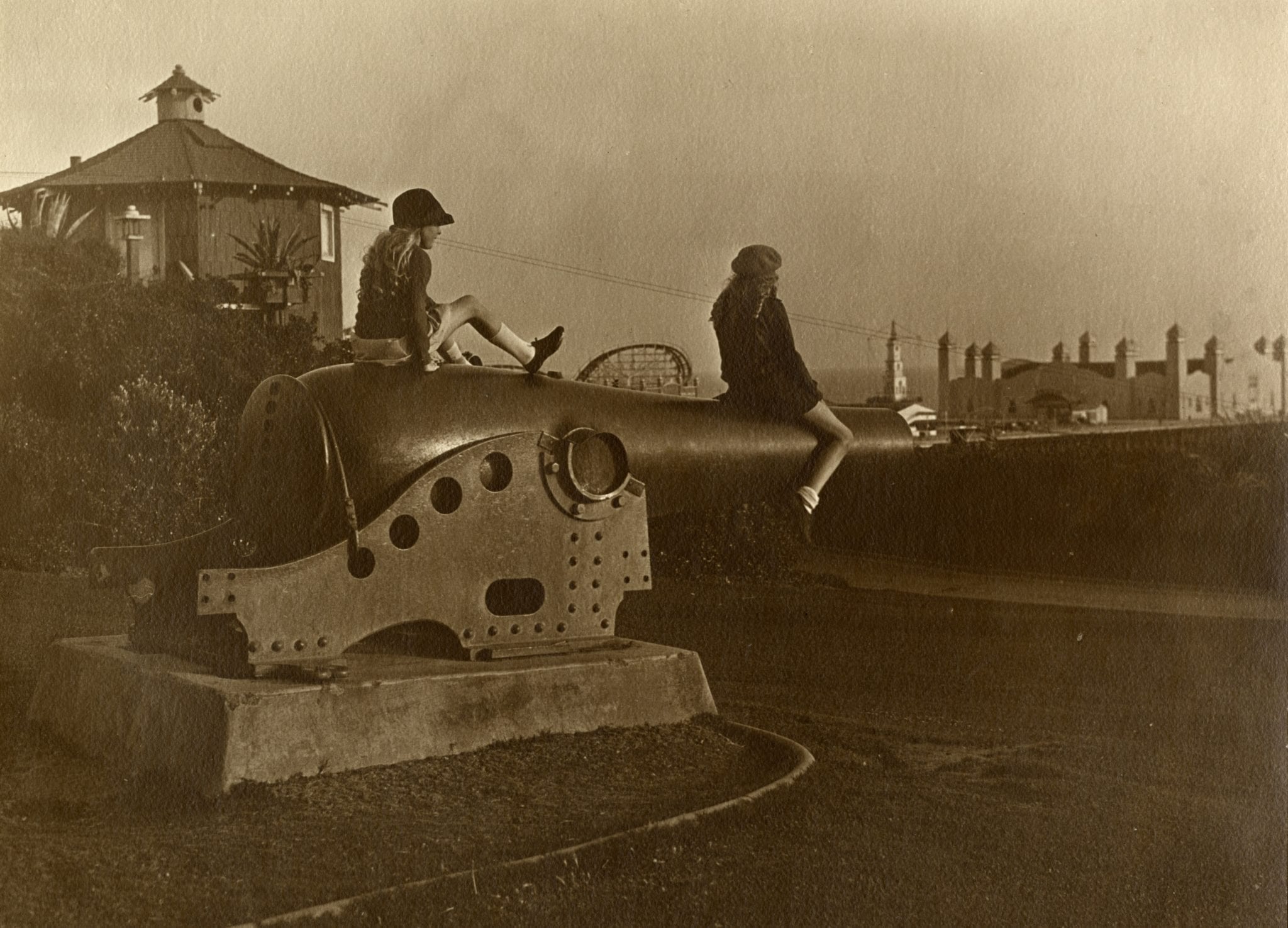 Two young girls sit atop a cannon in Palisades Park