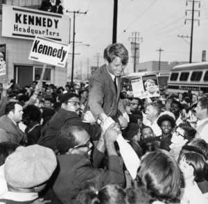 Robert Kennedy shaking hands in a crowd of people