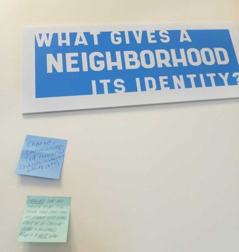 post-its on wall next to a question: What gives a neighborhood its identity?