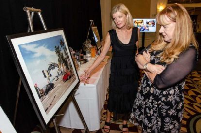 two people looking at framed photo at a gala silent aution