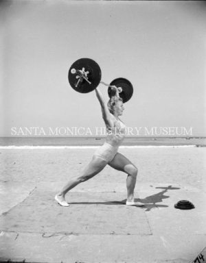 Gymnast Abbye Stockton lifting weights at Muscle Beach