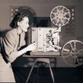 Picture of women behind a film projector (3.2.6047)